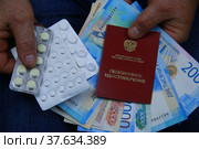 Pension certificate, Russian money and pills in men's hands. Стоковое фото, фотограф Понятова Юлия / Фотобанк Лори