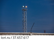 Lighting mast with floodlight at oil refinery plant against blue sky background.. Стоковое фото, фотограф Alexey Rezvykh / Фотобанк Лори