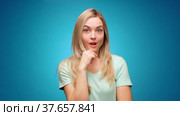 Blonde woman thinking over smart idea, pondering, against blue background. Стоковое видео, видеограф Сергей Толмачёв / Фотобанк Лори