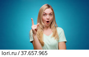 Blonde woman thinking over smart idea, pondering, against blue background. Стоковое видео, видеограф Сергей Толмачёв / Фотобанк Лори