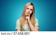 Blonde woman thinking over smart idea, pondering, against blue background. Стоковое видео, видеограф Сергей Толмачёв / Фотобанк Лори