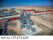 Oil refinery plant in desert sand. Panorama. Red pipes, heat exchanger, other metal equipment and red valves. Стоковое фото, фотограф Alexey Rezvykh / Фотобанк Лори