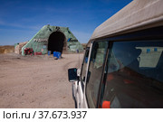 Khromtau, Aktobe region, Kazakhstan - May 06 2012: Gold ore mine portal. Title: "Quarry" and Mechel company logo. Blue sky and desert. Off-road car on foreground (right) Редакционное фото, фотограф Alexey Rezvykh / Фотобанк Лори
