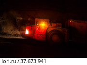 Khromtau, Aktobe region, Kazakhstan - May 06 2012: Gold ore mine underground gallery. Orange mine truck. With orange lights. Редакционное фото, фотограф Alexey Rezvykh / Фотобанк Лори