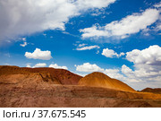 Aluminium ore quarry. Bauxite open cast (open cut) mining. Big yellow heaps of empty rocks. Blue sky with clouds. Стоковое фото, фотограф Alexey Rezvykh / Фотобанк Лори