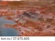 Aluminium ore quarry. Bauxite red clay open-cut mining. Quarry steps of various color minerals. Quarry lake (left). Стоковое фото, фотограф Alexey Rezvykh / Фотобанк Лори