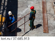 Ekibastuz, Pavlodar region, Kazakhstan - May 28, 2012: GRES-1 steam power station. Industrial climbers (builders) on metal roof. No face. Стоковое фото, фотограф Alexey Rezvykh / Фотобанк Лори