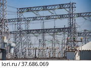 Electric pylons and cables on distribution and transformer substation. Blue sky background. Стоковое фото, фотограф Alexey Rezvykh / Фотобанк Лори