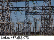 Electric pylons and wires. Distributing substation close-up. Blue sky background. Стоковое фото, фотограф Alexey Rezvykh / Фотобанк Лори