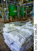 Caustic chemical plant. Plastic bags with barium chloride. Chemical reactor on background. Title on bags: Barium chloride (2012 год). Редакционное фото, фотограф Alexey Rezvykh / Фотобанк Лори