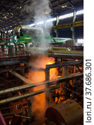 Aksu, Pavlodar region, Kazakhstan - May 29, 2012: Aksu steam power station workshop. Steam with orange light. Green electric machine on background, blurred. Редакционное фото, фотограф Alexey Rezvykh / Фотобанк Лори