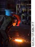 Aksu, Pavlodar region, Kazakhstan - May 29, 2012: Aksu steam power station. Welder worker in orange hardhat welding metal grid floor. Редакционное фото, фотограф Alexey Rezvykh / Фотобанк Лори