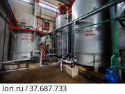 Almaty region, Kazakhstan-June 04,2012:Extraction of gold ore.Mining and processing plant of Altynalmas company.Stainless steel chemical reactor. Sodium cyanide NaCN production.Worker on background. Редакционное фото, фотограф Alexey Rezvykh / Фотобанк Лори