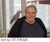 Man with a Jaco parrot on his shoulder. Стоковое фото, фотограф Argument / Фотобанк Лори