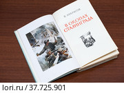 Раскрытая книга в окопах Сталинграда лежит на столе (2022 год). Редакционное фото, фотограф Игорь Низов / Фотобанк Лори