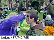 Гример наносит на лицо ребенка аквагрим (2022 год). Редакционное фото, фотограф Лариса Вишневская / Фотобанк Лори