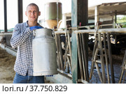 Farmer with milk churn standing near cowshed at dairy farm. Стоковое фото, фотограф Яков Филимонов / Фотобанк Лори