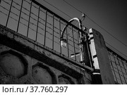 Бетонный забор с колючей проволокой, черно-белое фото. Стоковое фото, фотограф Виталий Михайлюк / Фотобанк Лори