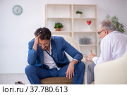 Young businessman employee visiting psychologist. Стоковое фото, фотограф Elnur / Фотобанк Лори