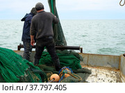 Рыбаки на рыболовном судне. Моряки работают с тралом. Рыбацкая сеть. Ловля рыбы неводом. Стоковое фото, фотограф Виктор Истомин / Фотобанк Лори