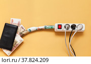 Concept of payment for the electricity. Russian ruble banknotes are leaking from consumers' wallets into electrical outlets. Rising utility bills. Flat lay, copy space, empty place for text, top view, mock up. Стоковое фото, фотограф Виктория Катьянова / Фотобанк Лори