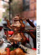 Turkish traditional tea in tulip-shaped glass with cupper colored double teapot. Стоковое фото, фотограф Юлия Паутова / Фотобанк Лори