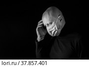 Мужчина в медицинской маске, чёрно-белое фото. Смертельный вирус. Эмоции больного. Стоковое фото, фотограф Виталий Михайлюк / Фотобанк Лори
