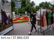 Сотрудница переносит одежду с модного показа на площадке фестиваля Московская неделя моды на Страстном бульваре в центре города Москвы, Россия (2022 год). Редакционное фото, фотограф Николай Винокуров / Фотобанк Лори