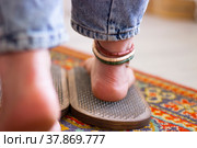 Women's feet stand on a board with sharp nails. Sadhu board. Pain, trials, health, relaxation, cognition. Close-up. Стоковое фото, фотограф Подгорная Юлия / Фотобанк Лори