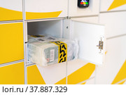 Moscow, Russia - June 17. 2022. Parcel from the delivery service Yandex Market in cell postamat. Редакционное фото, фотограф Володина Ольга / Фотобанк Лори