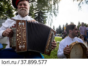 Казак играет на гармони на площадке фестиваля в парке "Музеон", Россия (2022 год). Редакционное фото, фотограф Николай Винокуров / Фотобанк Лори