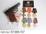 Травматический пистолет, удостоверение ветерана боевых действий, деньги, медали на белом фоне (2022 год). Редакционное фото, фотограф хохрякова альбина накиповна / Фотобанк Лори