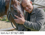 Мужчина обнимает лошадь. Верный конь. (2020 год). Редакционное фото, фотограф Виталий Михайлюк / Фотобанк Лори