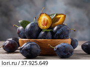 Full plate of ripe prune fruits on a wooden table. Стоковое фото, фотограф Сергей Чайко / Фотобанк Лори