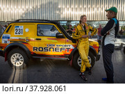 Евгений Загороднюк у автомобиля команды LADA Sport ROSNEFT Raid принимает участие во время торжественной церемонии награждения участников международного ралли "Шелковый путь" в "Лужниках" города Москвы, Россия (2022 год). Редакционное фото, фотограф Николай Винокуров / Фотобанк Лори