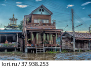 A serene warren of canals, floating houses and stilt houses over the Chao Phraya River, at Krung Thon Bridge (Saphan Sang Hi) (2019 год). Стоковое фото, фотограф Анна Кривицкая / Фотобанк Лори