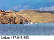 Baikal Lake at summer. View of Bazarnaya Bay in the Olkhon Gate Strait and the tourist Sakhyurta village MRS with wooden houses on rocky shore. Summer travel and lakeside recreation (2022 год). Стоковое фото, фотограф Виктория Катьянова / Фотобанк Лори