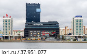 Minsk, Belarus - January 07, 2018: The building of the DoubleTree by Hilton hotel and shopping center in the center of Minsk.  View from the Svisloch river embankment. Редакционное фото, фотограф Denis Shitikoff / Фотобанк Лори