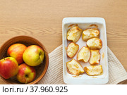 Freshly baked sweet apples in a ceramic form on a wooden table. Delicious organic sweets rich in fiber. Digestible food for elderly people, children and people with health problems. Flat lay, copy space. Стоковое фото, фотограф Виктория Катьянова / Фотобанк Лори