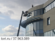 Moscow / Russian Federation - April 6 2019: people repair the lining of the office building. Редакционное фото, фотограф Марина Шабардина / Фотобанк Лори