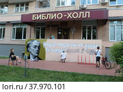 Улыбчивы уличный художник Сергей Юраков расписывает стену центральной библиотеки имени Ф.И. Тютчева в Балашихе (2022 год). Редакционное фото, фотограф Дмитрий Неумоин / Фотобанк Лори