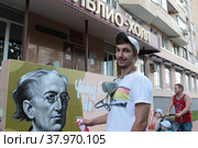 Уличный художник Сергей Юраков расписывает стену центральной библиотеки имени Ф.И. Тютчева в Балашихе (2022 год). Редакционное фото, фотограф Дмитрий Неумоин / Фотобанк Лори