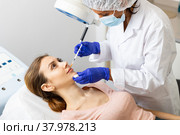 Cosmetologist making injections of botulotoxin into lips of young woman. Стоковое фото, фотограф Яков Филимонов / Фотобанк Лори