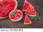 Кусочки, дольки и половина спелого сочного арбуза, крупным планом на деревянном фоне. Стоковое фото, фотограф Владимир Ходатаев / Фотобанк Лори
