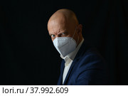Мужчина в медицинской маске на чёрном фоне. Стоковое фото, фотограф Виталий Михайлюк / Фотобанк Лори