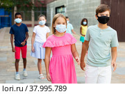 Pair of young people in masks walking hand in hand. Стоковое фото, фотограф Яков Филимонов / Фотобанк Лори