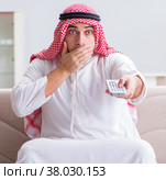 Arab man watching tv at home. Стоковое фото, фотограф Elnur / Фотобанк Лори