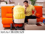 Young man looking after new born at home. Стоковое фото, фотограф Elnur / Фотобанк Лори