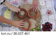 Various food at the picnic and women disassembling bagels from the stand. Стоковое видео, видеограф Константин Шишкин / Фотобанк Лори