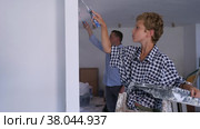 Father and son using paint rollers to decorate wall in new apartment. Стоковое видео, видеограф Яков Филимонов / Фотобанк Лори